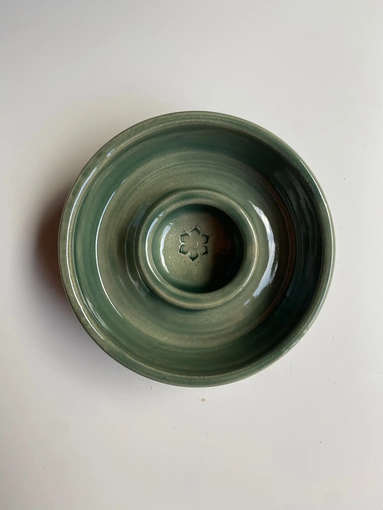 Handgemaakte keramieken hondenbak set van Iris Floor in mosgroen glazuur. De set bevat een functionele slowfeeder en een bijpassende drinkbak met een uniek ambachtelijk swirl-effect.