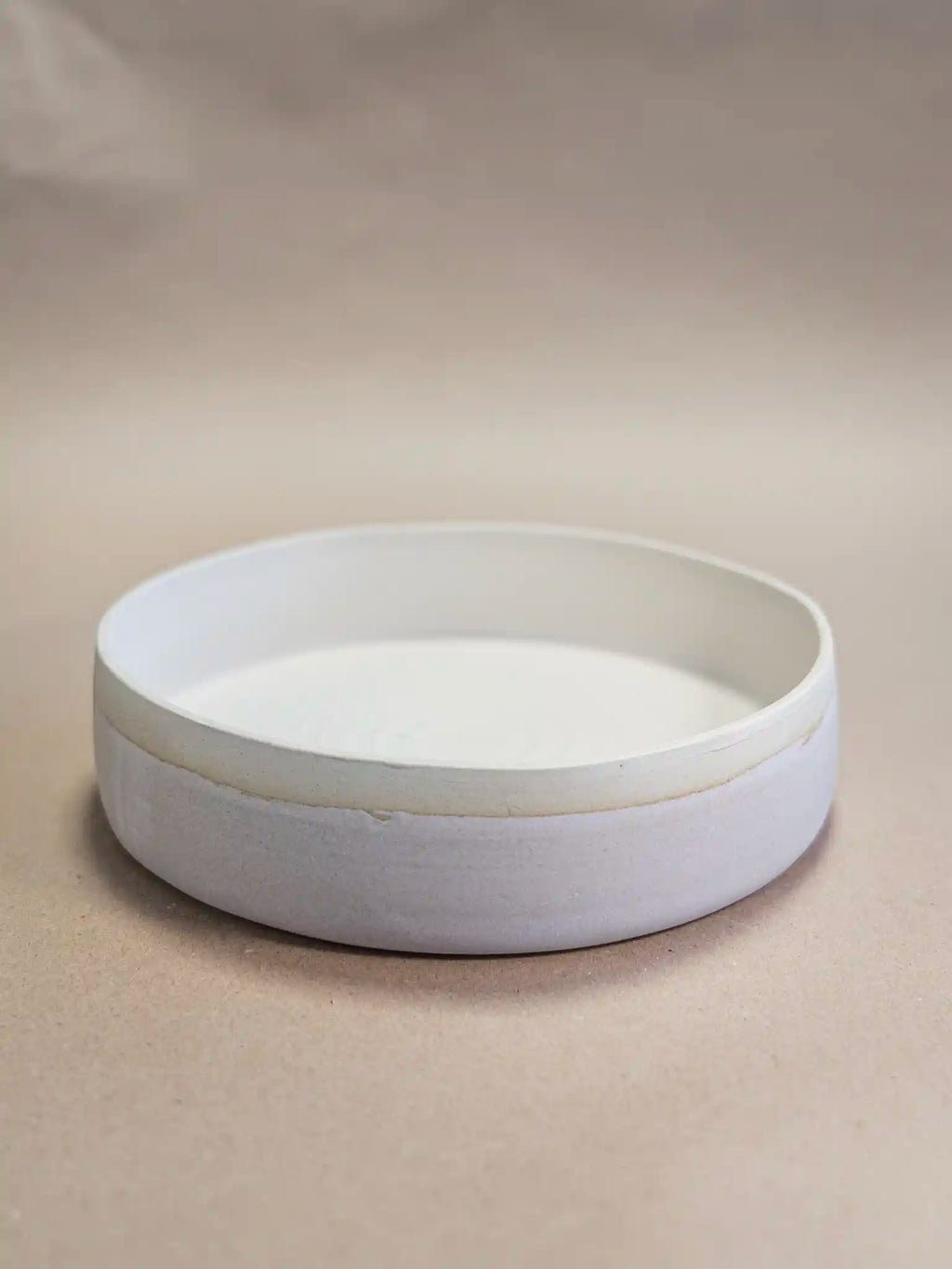 Handgemaakt keramiek serveerplateau in mat marmer glazuur met ongeglazuurde rand, zijaanzicht op beige achtergrond — Iris Floor Ceramics