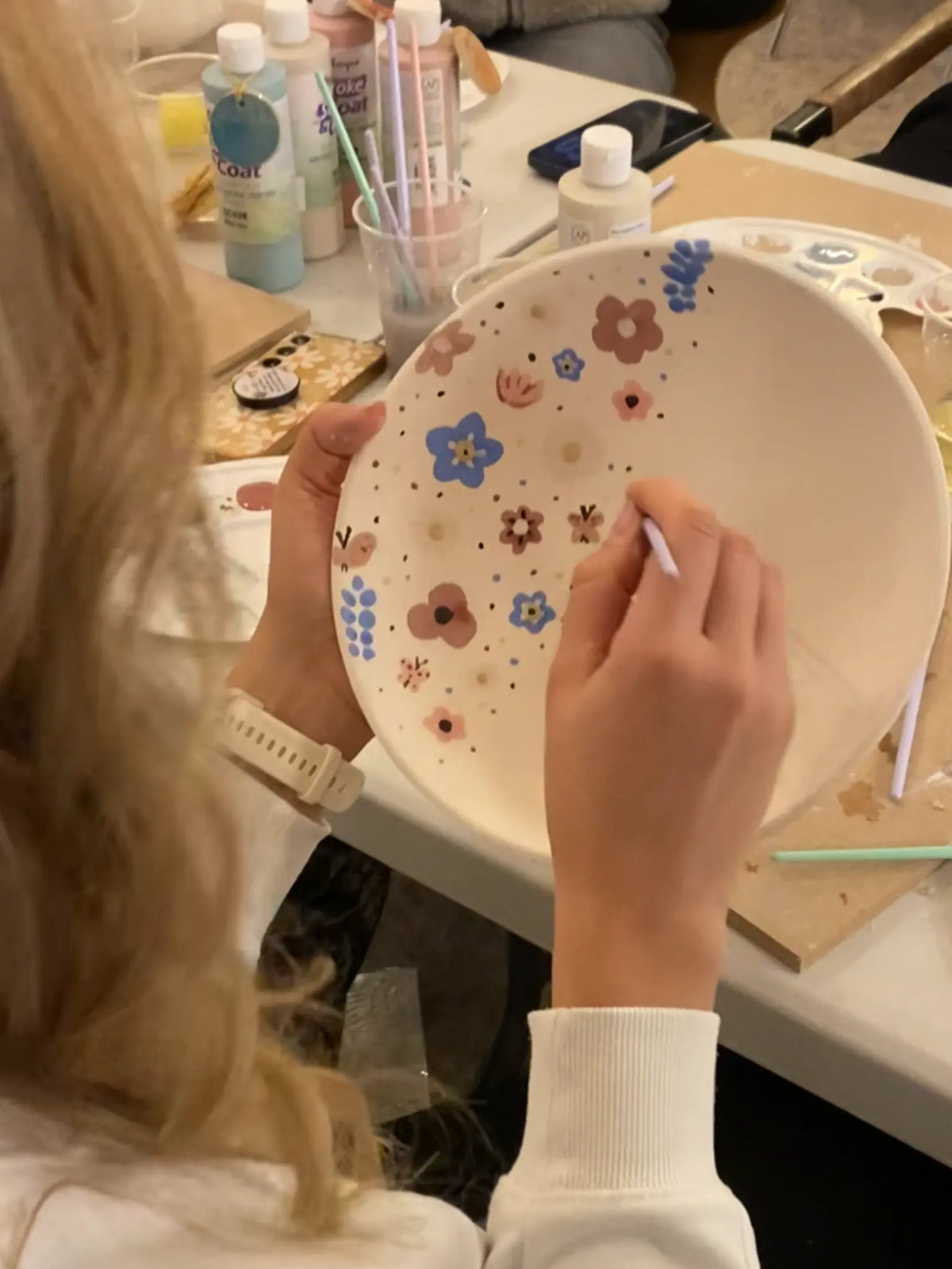 Creatieve workshop paaseieren schilderen bij Iris Floor. Deelnemers decoreren handgemaakt keramiek met vrolijke voorjaarsbloemen en vlinders met professioneel glazuur in een sfeervol atelier.